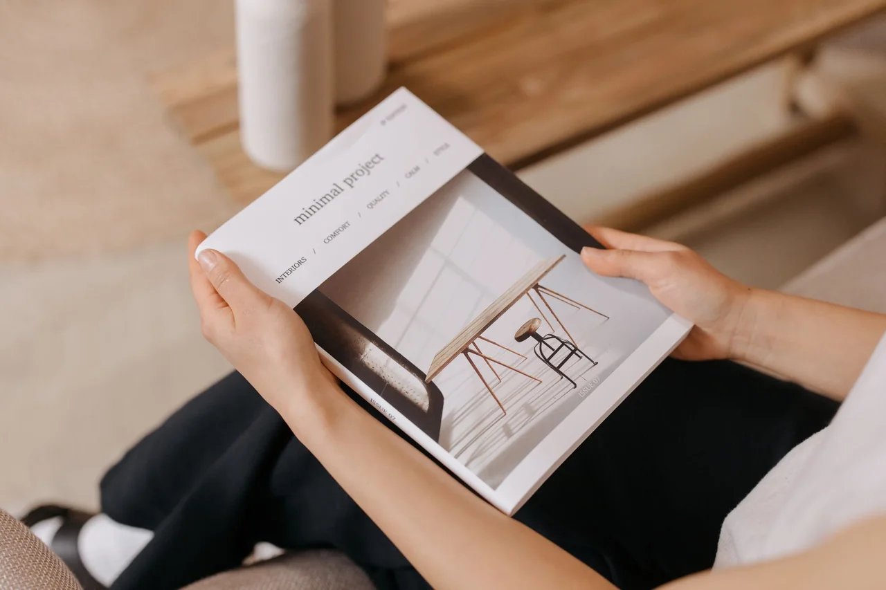 Designer reviewing tactile print magazine layout in natural studio light